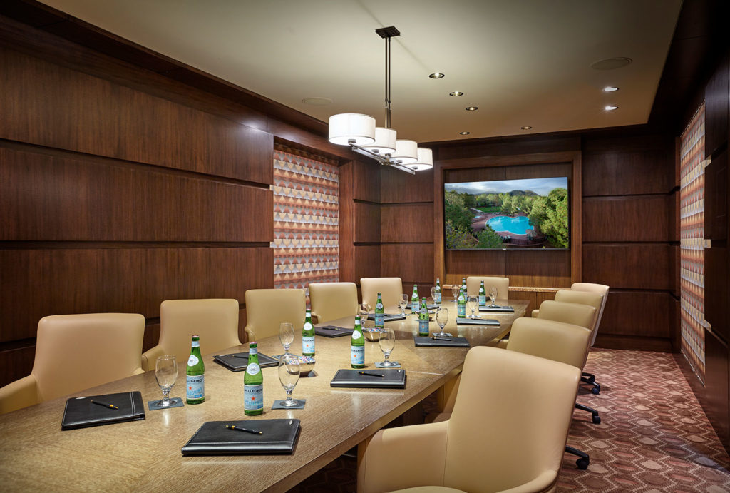 Executive Boardroom with a television, long meeting table, and chairs