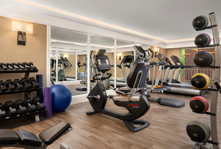 Fitness Center with a stationary bike, treadmills, free weights, and other exercise equipment.
